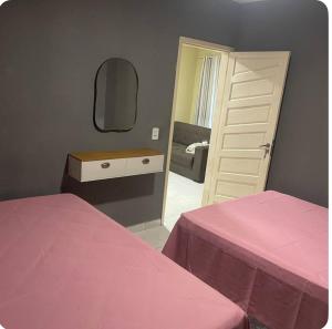 a bedroom with two beds and a mirror at Casa Maragogi in Maragogi