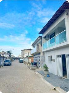 a street with a house and cars parked on the street at Casa Maragogi in Maragogi