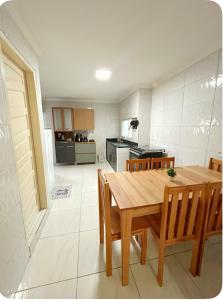 a kitchen and dining room with a wooden table and chairs at Casa Maragogi in Maragogi