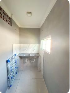 a white bathroom with a sink and a window at Casa Maragogi in Maragogi