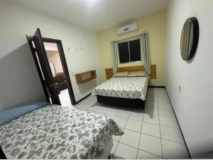 a bedroom with two beds and a window at Apartamento Amarelinho - Canoa Quebrada in Aracati