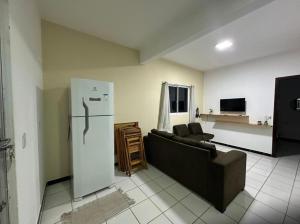 a living room with a couch and a refrigerator at Apartamento Amarelinho - Canoa Quebrada in Aracati