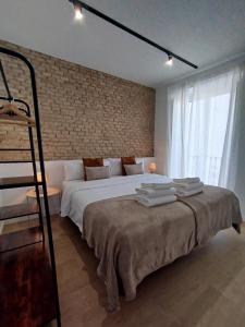 a bedroom with a large bed and a brick wall at TAYP Sol 120 in Seville