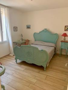 a bedroom with a bed with a green frame at La Bigotière avec clim et jardin in Arles