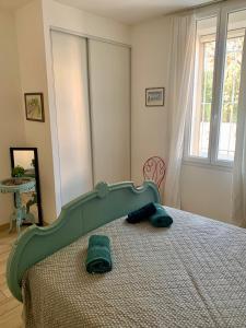 a bedroom with a bed with a green head board at La Bigotière avec clim et jardin in Arles