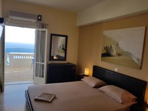 a bedroom with a bed with a view of the ocean at Villa Aphrodite in Achlia