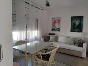 een woonkamer met een glazen tafel en een bank bij Suite de invitados independiente in Cerdanyola del Valles