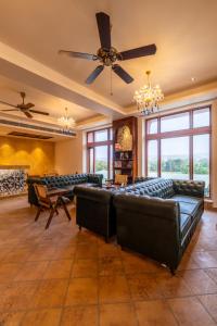 a large living room with couches and a ceiling fan at SeraiBagh Resort in Khilchipur