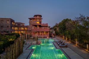 a swimming pool with green lights in front of a building at SeraiBagh Resort in Khilchipur