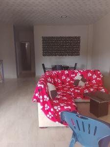 a bedroom with a bed with a red blanket and a couch at Villa comoda in Puerto López +3 photos