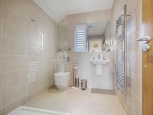 ein Badezimmer mit Toilette und Waschbecken in der Unterkunft Knighton - Luxury Dorset lakeside home, sleeps 12 with spa and pool access in Warmwell + 19 Fotos