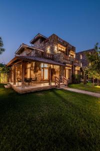 a large stone house with a lawn in front of it at SeraiBagh Resort in Khilchipur