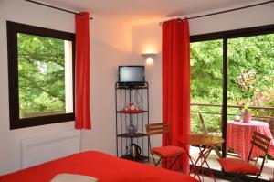 a bedroom with red curtains and a bed and a window at La Villa Antalya in Ault