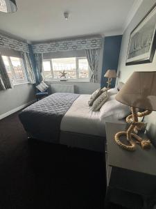 ein Schlafzimmer mit einem großen Bett und einem Tisch mit einer Lampe in der Unterkunft Salt on the Harbour in Bridlington