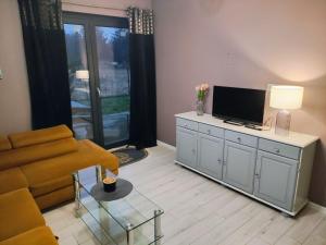 a living room with a couch and a tv at Apartament na Chmielnej in Rychwał