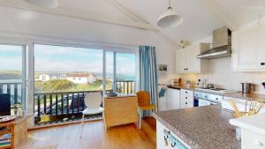 a kitchen with a large window with a view of the ocean at D22 Sandelite, Riviere Towans in Hayle