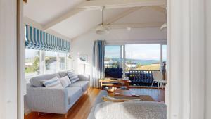 a living room with a couch and a view of the ocean at D22 Sandelite, Riviere Towans in Hayle