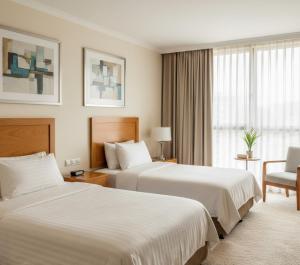 una stanza d'albergo con due letti e una sedia di Zafer Hotel a Malatya