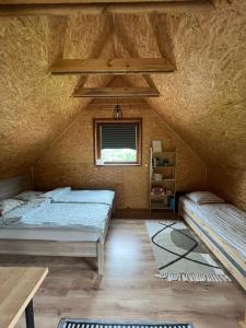 a room with two beds and a table and a window at Domek LuźnAgro Góry Sowie in Łomnica