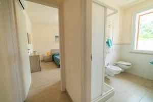 a white bathroom with a toilet and a window at Golfo di Lacona in Lacona +19 photos