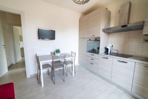 a kitchen with a table with chairs and a tv at Golfo di Lacona in Lacona