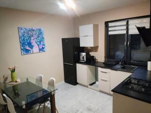 a kitchen with a glass table and a black refrigerator at Apartament na Chmielnej in Rychwał