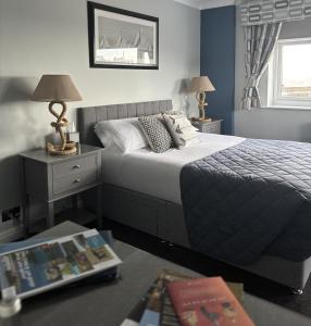 ein Schlafzimmer mit einem Bett und einem Tisch mit Lampen in der Unterkunft Salt on the Harbour in Bridlington
