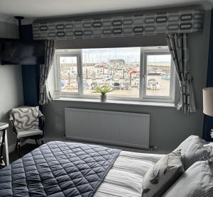 Schlafzimmer mit einem Bett und einem Fenster mit Hafenblick in der Unterkunft Salt on the Harbour in Bridlington