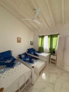 ルハン・デ・クージョにあるArtin House Mendozaの緑のカーテンがかかった部屋にベッドが2つ +16枚の写真