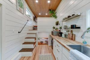 una cucina con pareti bianche e scale in una piccola casa di Tiny Islands Resort - Kauai a Fischer