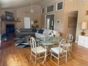 un soggiorno con tavolo e sedie in vetro di Fun Beach House With Pool Alligator Point a Sun N Sand Beaches