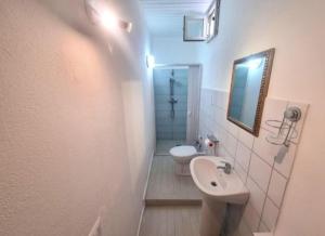 a bathroom with a sink and a toilet and a mirror at I Venti di Vulcano in Vulcano