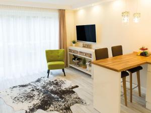 een woonkamer met een eettafel en een televisie bij Donau Lodge Boardinghouse in Straubing