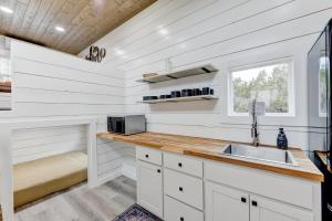 una cucina con mobili bianchi e un lavandino di Tiny Islands Resort - Canary a Fischer Altre 8 foto