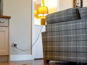 een woonkamer met een bank en een lamp bij Ninetrees - Uk47883 in Keilour