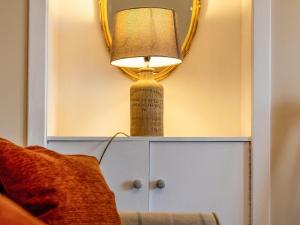 een lamp bovenop een kastje naast een bed bij Ninetrees - Uk47883 in Keilour