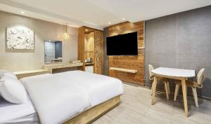 una camera da letto con un letto, un tavolo e una TV di Hotel Pacific a Suwon