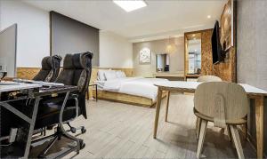 una camera da letto con un letto, un tavolo e delle sedie di Hotel Pacific a Suwon