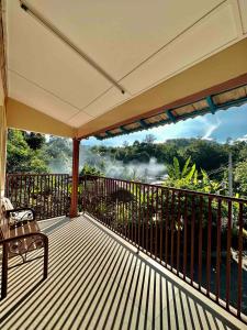 eine Holzterrasse mit einer Bank auf dem Balkon in der Unterkunft Cozy Little Retreat Walking Distance to Sg Rening in Batang Kali