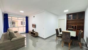 a living room with a table and a couch and a table and chairs at Edifício Aquarius in Ribeirão Preto