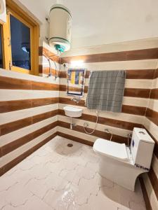 a bathroom with a toilet and a sink at Raj Hotel and Restaurant in Bhadarwāh