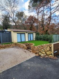 a house with a stone wall and a yard at escapade coeur provence in La Celle