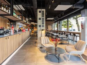 ein Restaurant mit Tisch und Stühlen und einer Bar in der Unterkunft ibis Madrid Norte Las Tablas in Madrid