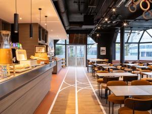 a restaurant with tables and chairs and a bar at ibis Styles Colombes Paris Ouest (Ouverture Octobre 2025) in Colombes