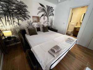 a bedroom with a large white bed with plants on the wall at Villa Alma Komiza Island Vis in Komiža