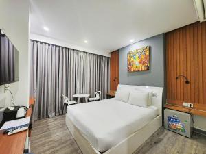 a hotel room with a bed and a table at ZODY Boutique Hotel in Ho Chi Minh City