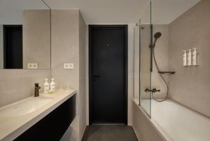 a bathroom with a glass shower and a sink at Courtyard by Marriott Ghent in Ghent