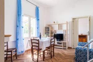 a dining room with a table and chairs and a tv at Villa Antonina & Mino in Cala Liberotto