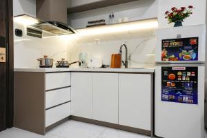 胡志明市Hera House l Vinhomes Grand Park的配有白色橱柜和冰箱的厨房