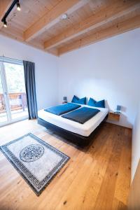 una camera da letto con un letto con lenzuola blu e un tappeto di Apartment Lorenz a Scharnitz